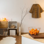 Contemporary decor of living room with wooden parquet and sheepskin. Unique shelves of natural hardwood